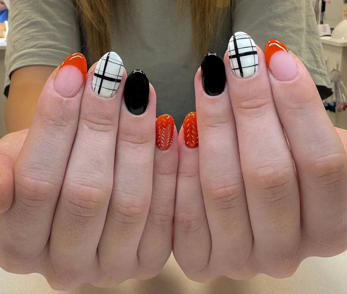 Orange French tips with black-and-white grid accents