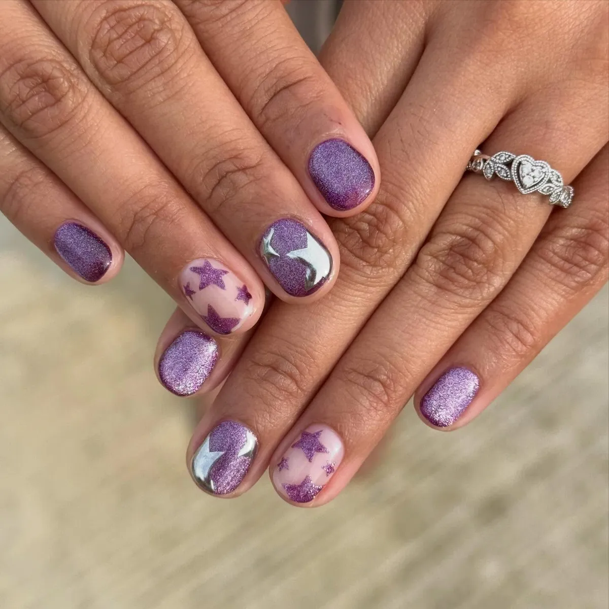 Purple shimmer short nails with star accents