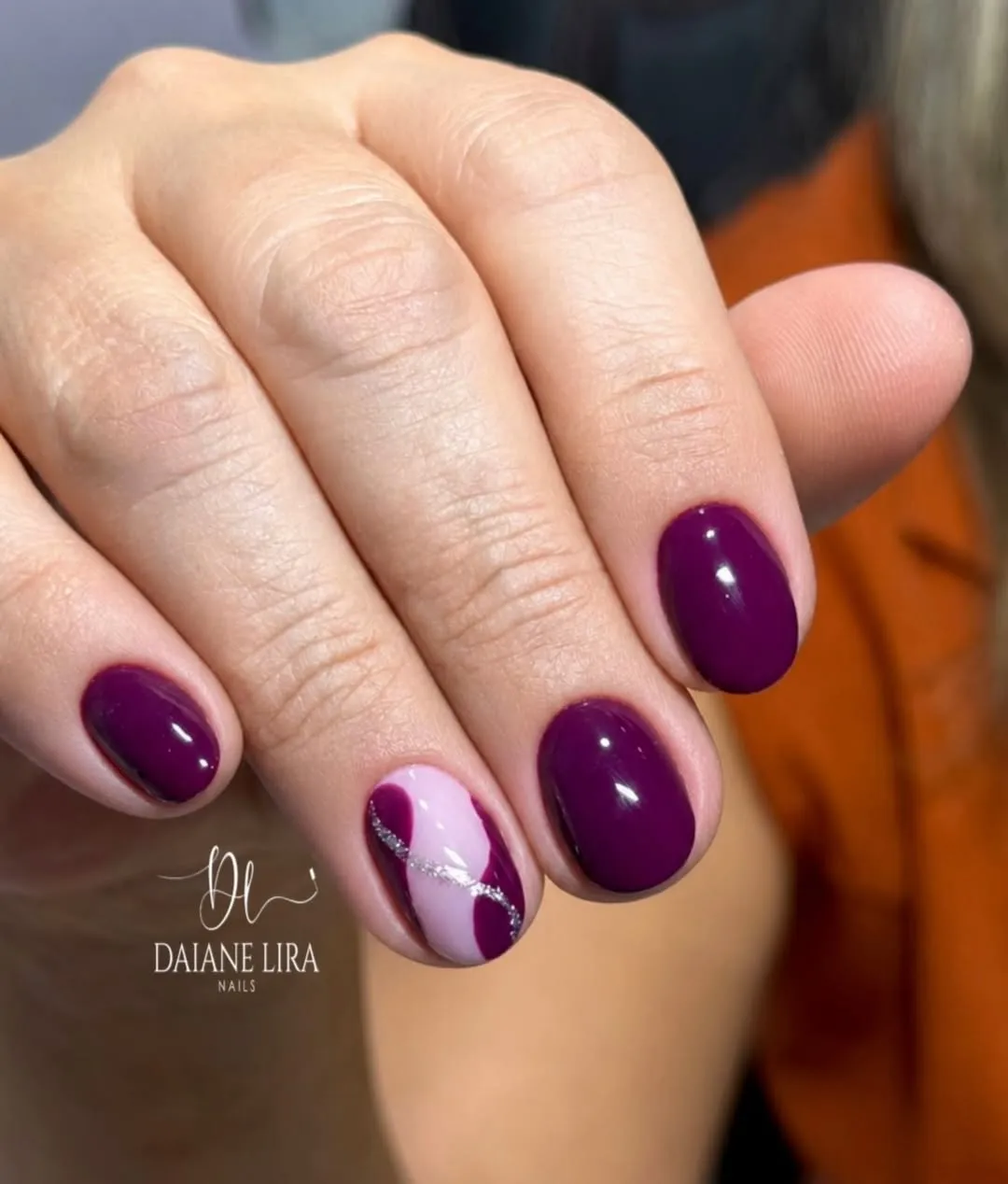 Deep plum with pink-and-silver swirl accent nail