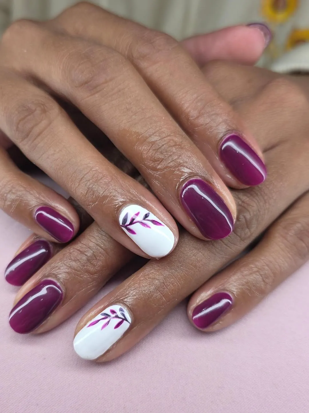Glossy plum nails with white botanical accent nails