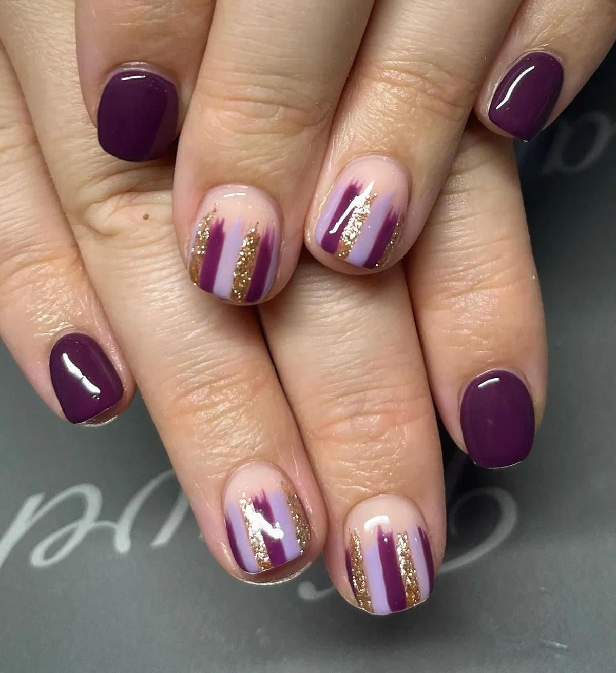 Deep plum with vertical brushstroke stripes and gold glitter accents