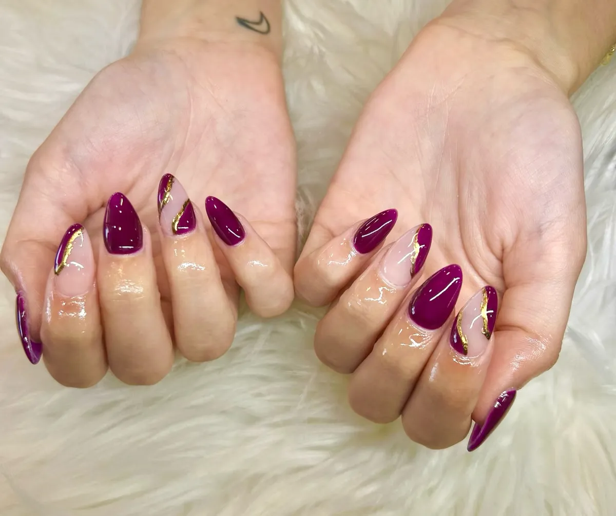 Deep Plum Stiletto Nails with Nude and Gold Diagonals