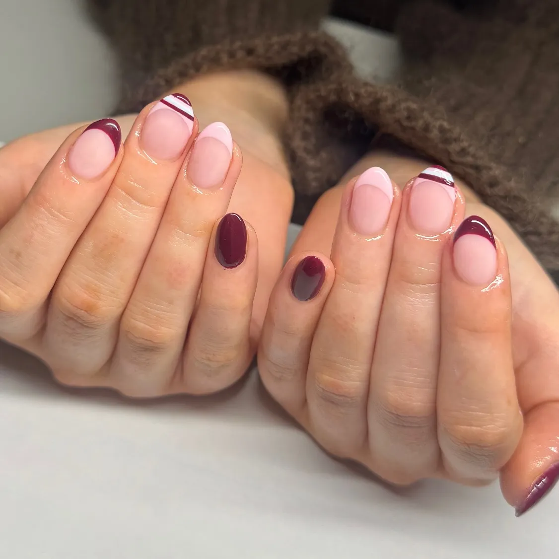 Short plum French tips with striped accent nail