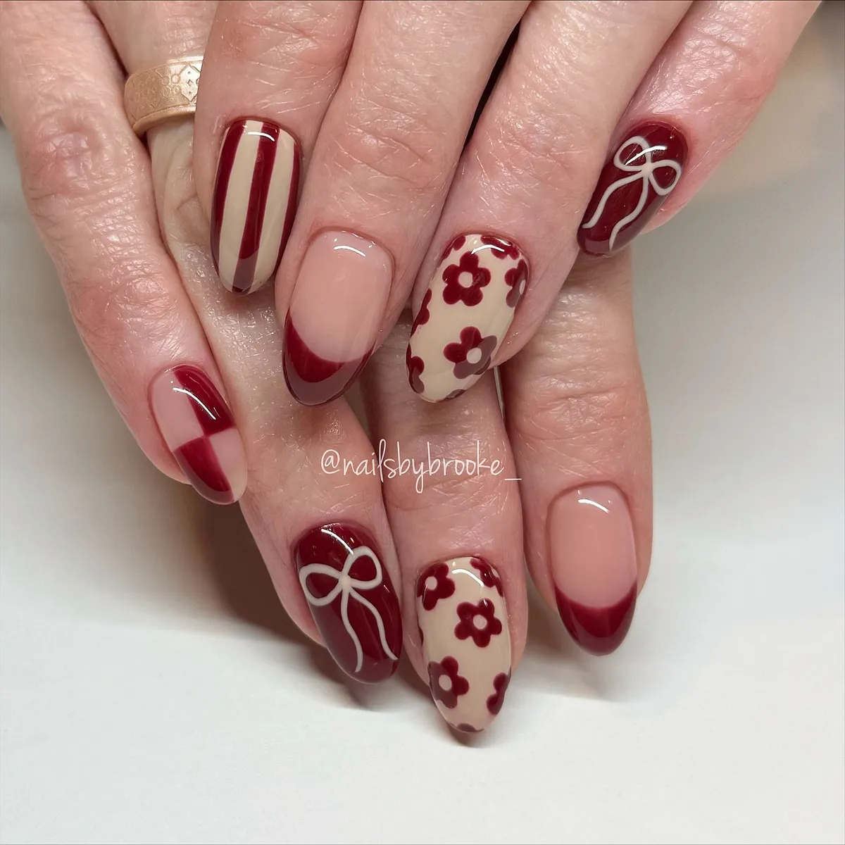 Burgundy French tips, florals, and bow accents