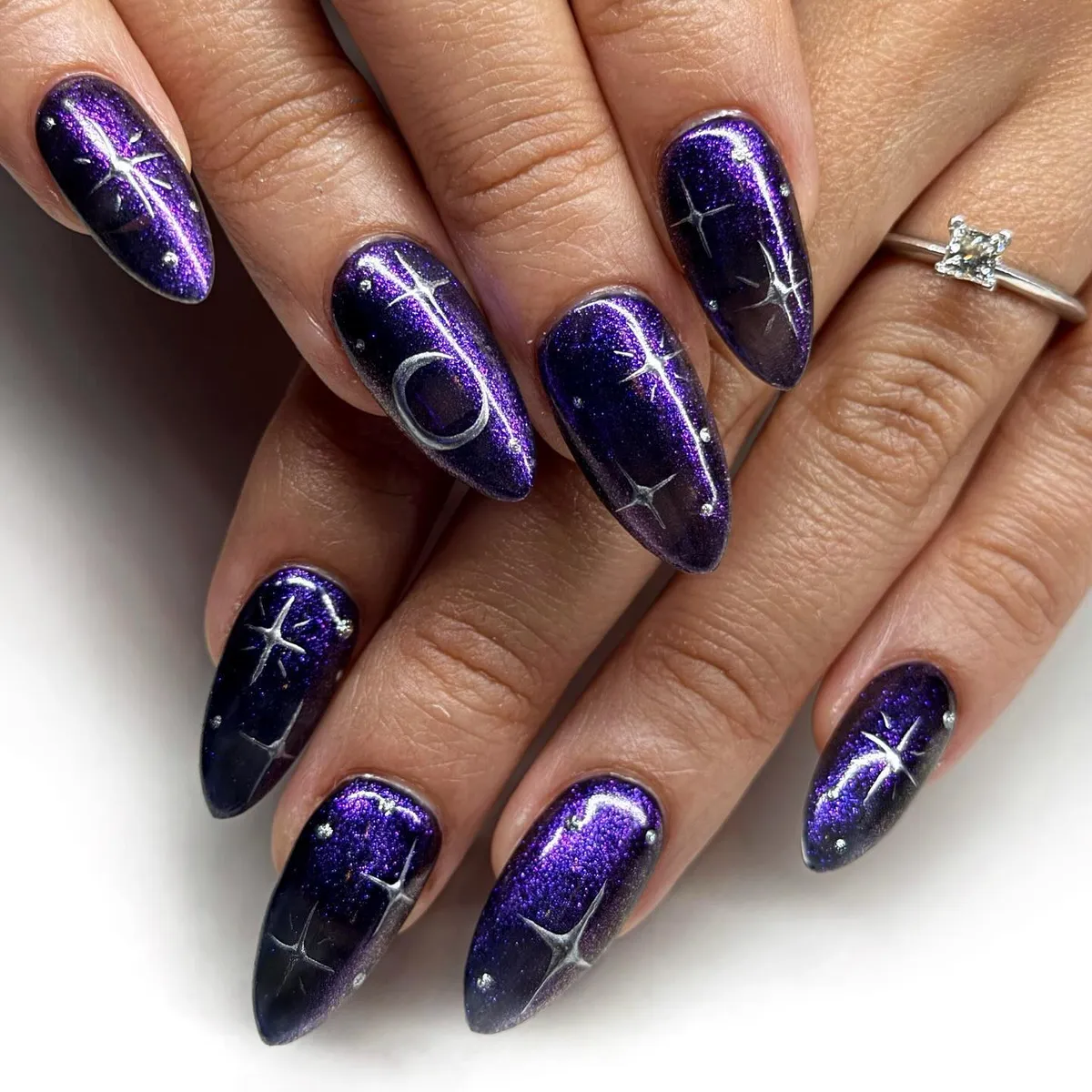 Metallic purple-black gradient with moon and starbursts