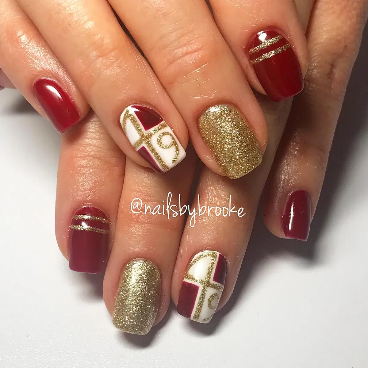 Deep red with gold glitter stripes and geometric white accents
