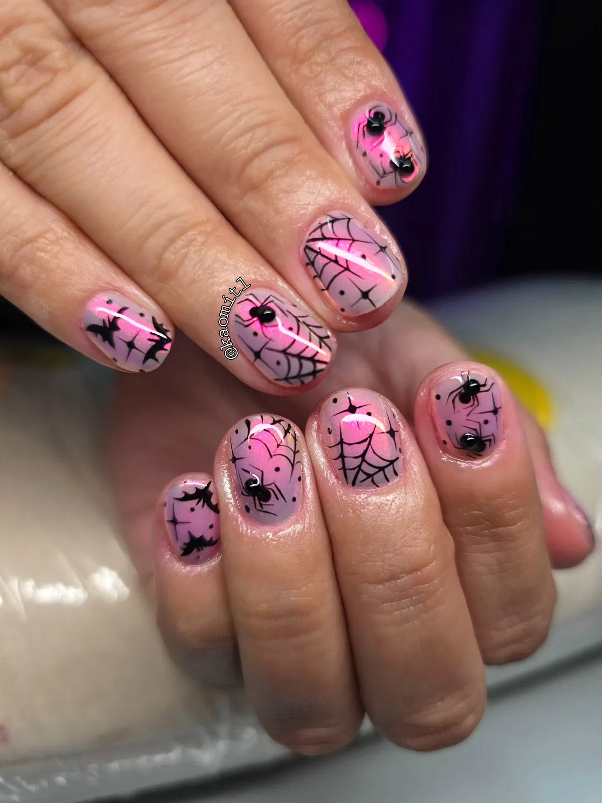 Pink-lavender gradient nails with black webs, spiders, and bats