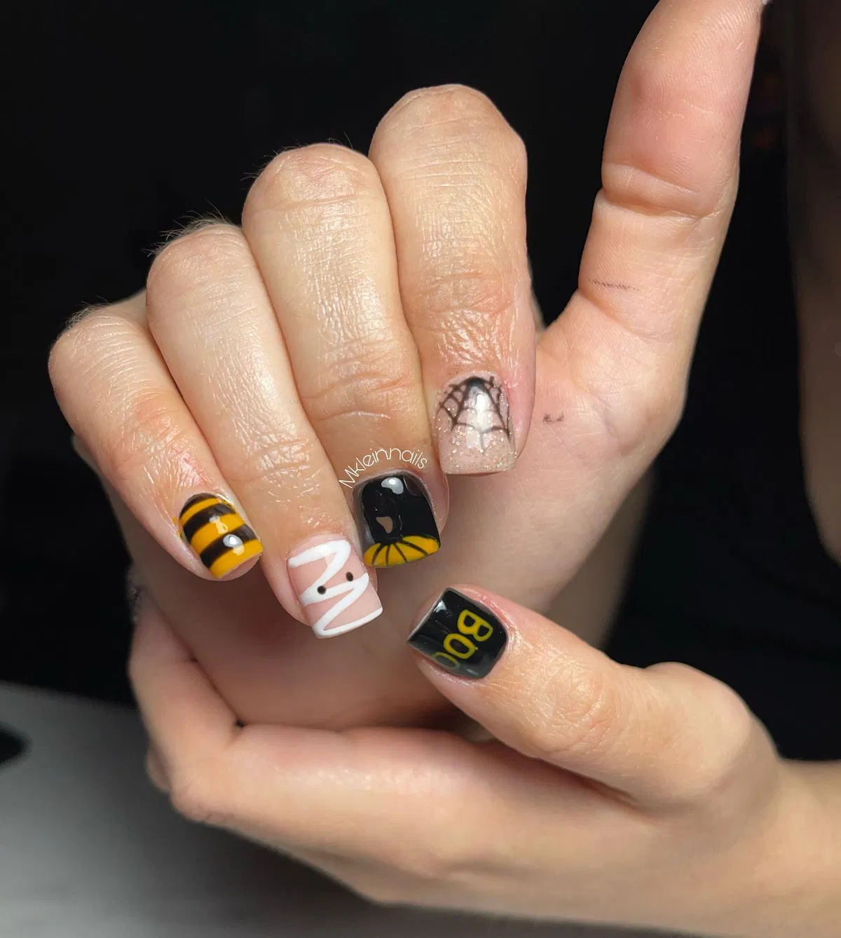 Black-and-yellow stripes with “BOO” text and web/wrap-line accents
