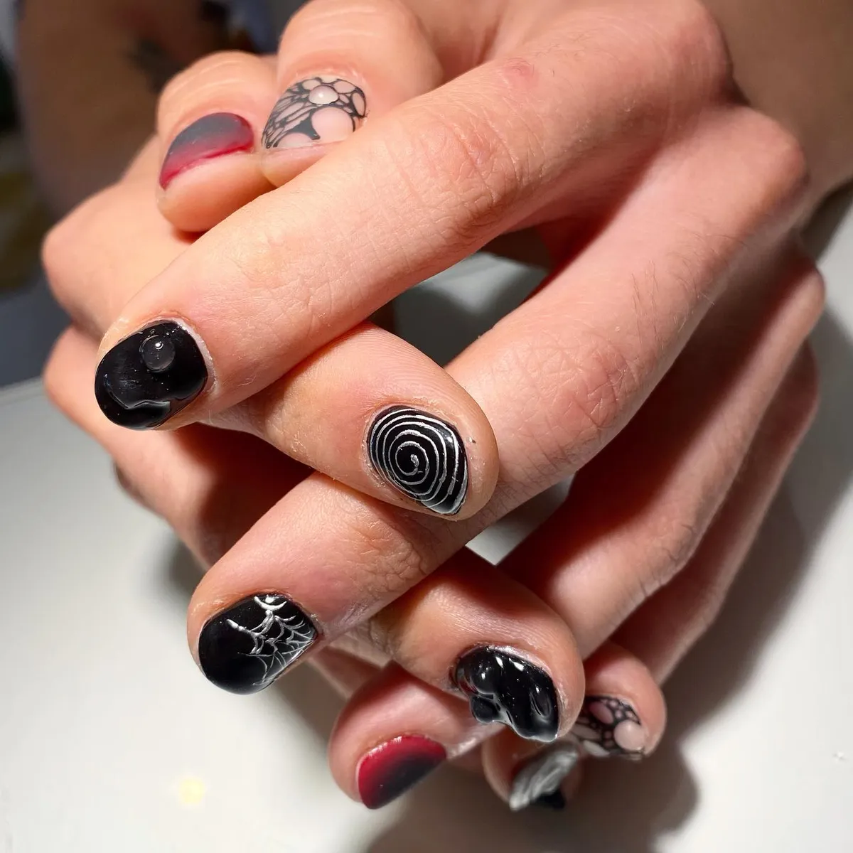Glossy black webs and spirals with a red-to-black accent