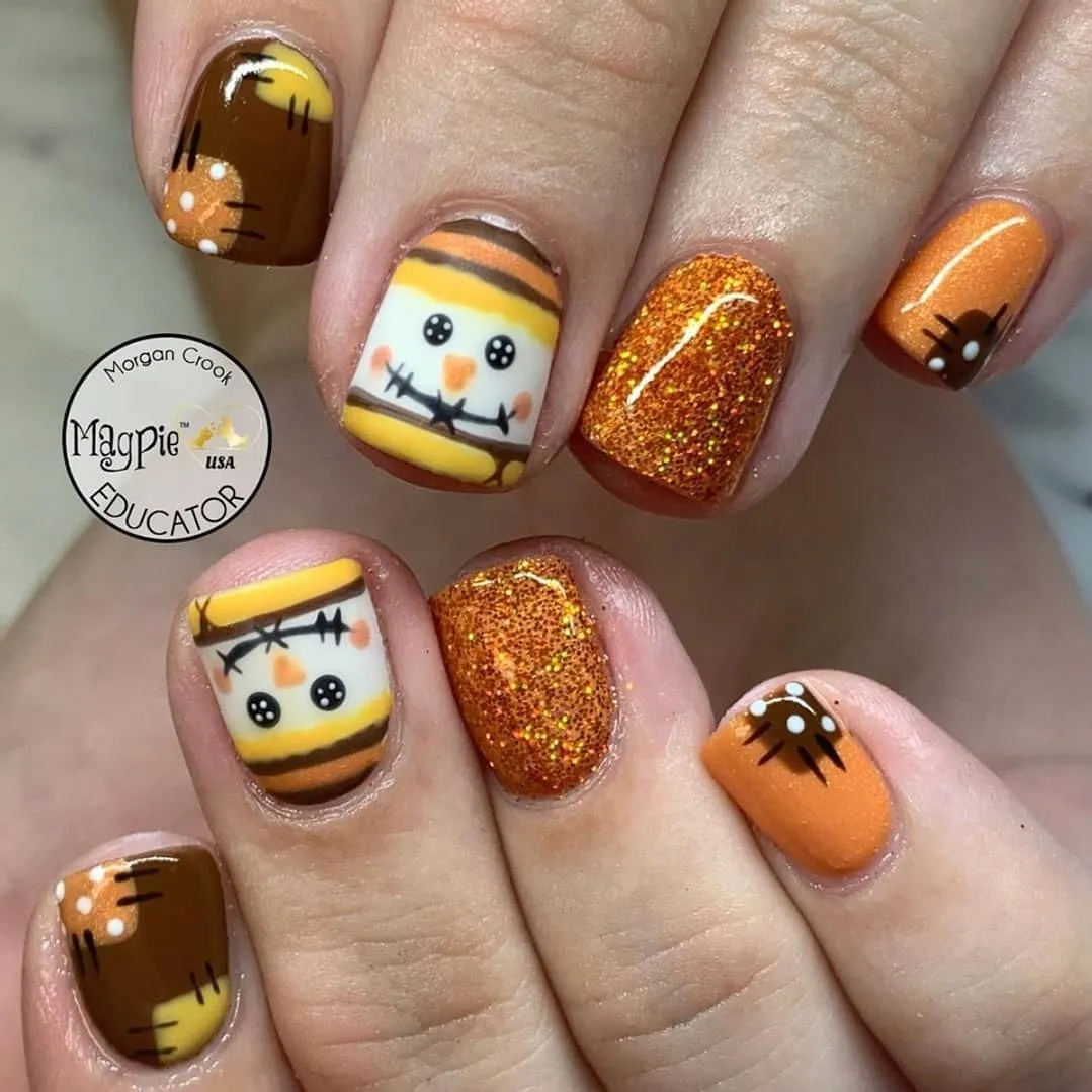 Orange glitter and character-style nail art