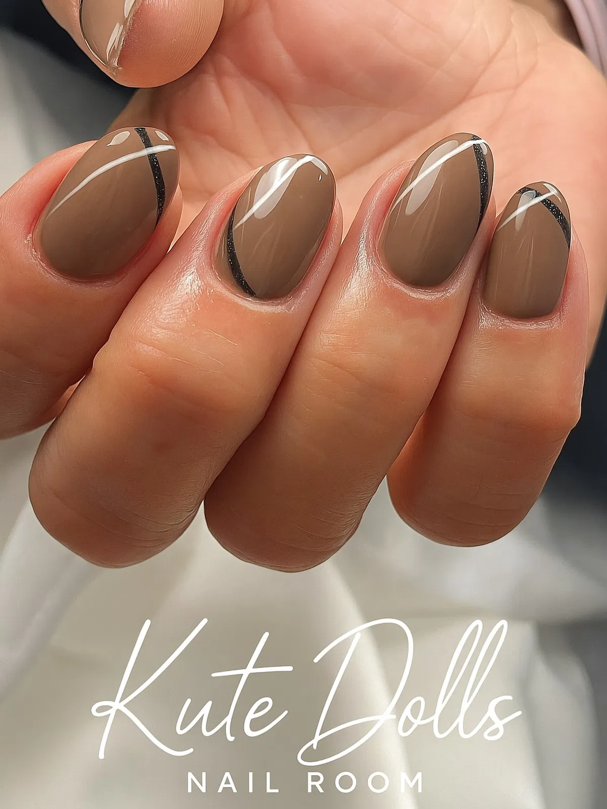 Taupe nails with curved black-and-white stripe details