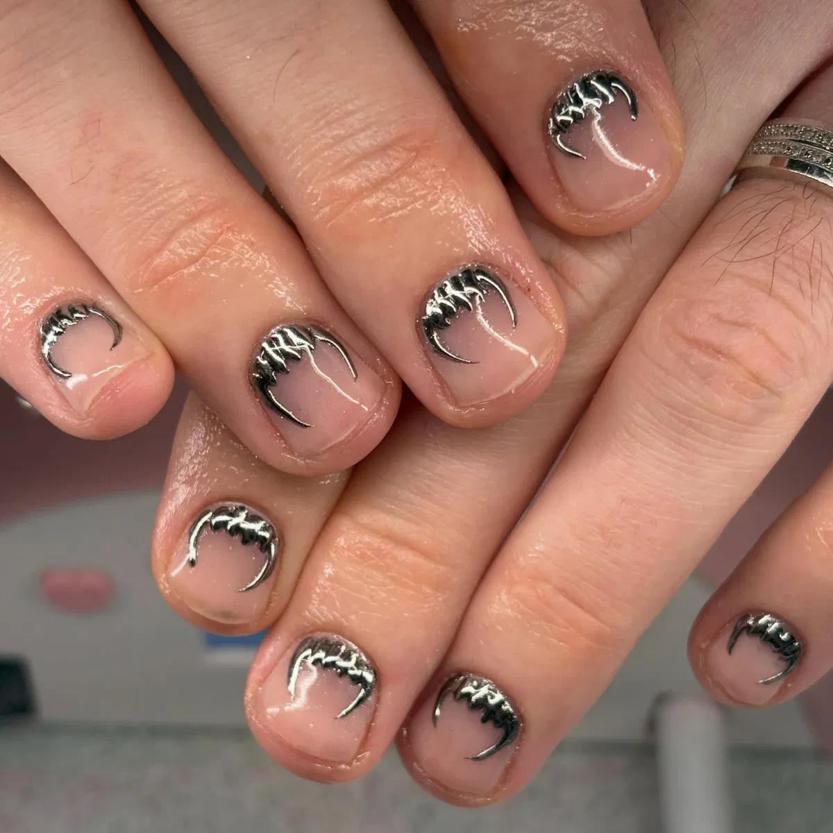 Minimal nude nails with silver fang arcs