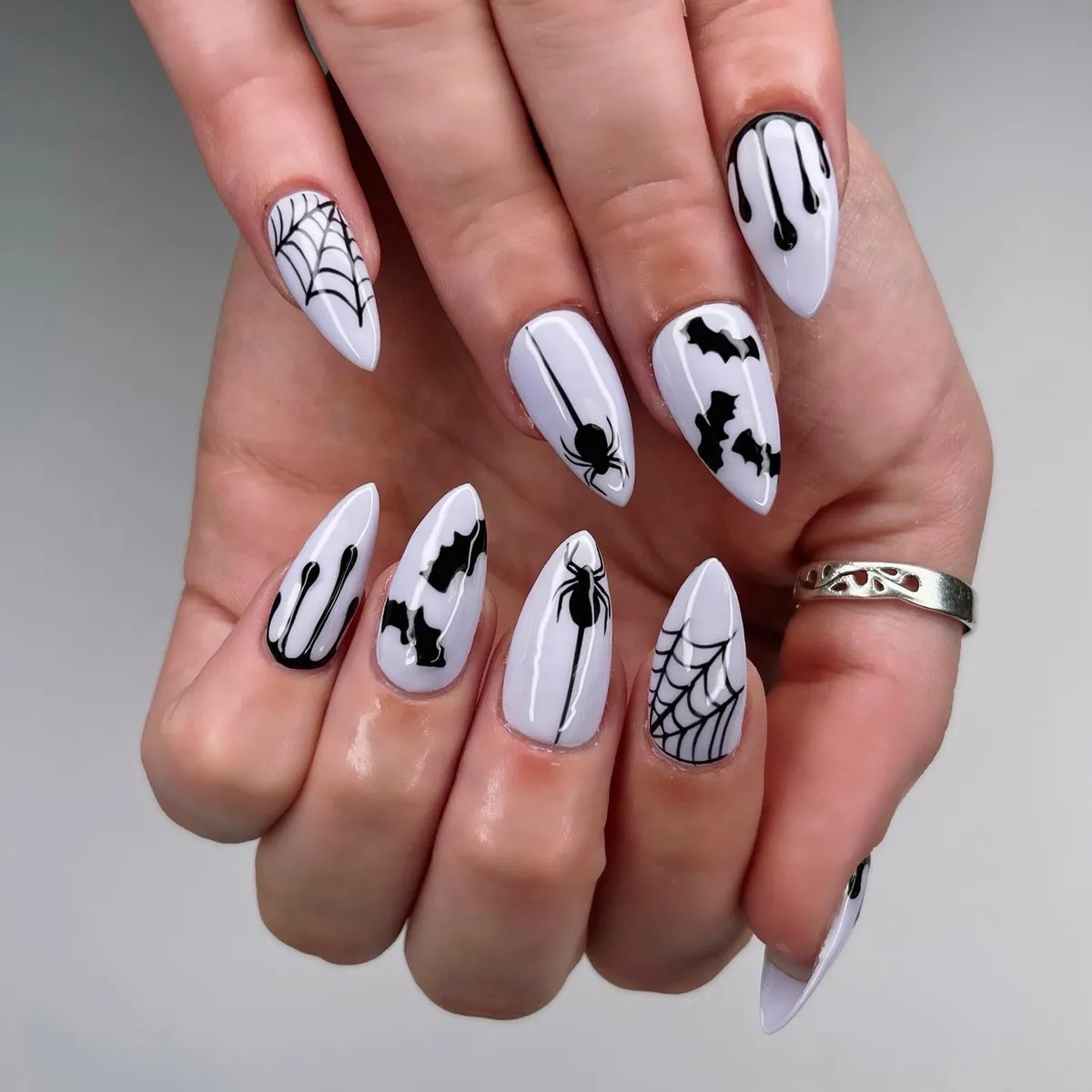 White nails with black webs, spiders, bats, and drips