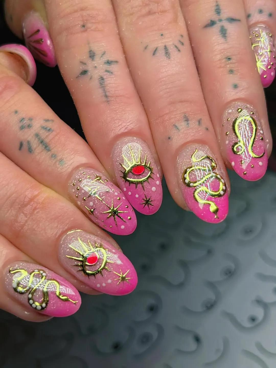 Pink ombré with gold-outlined symbols and eye detail
