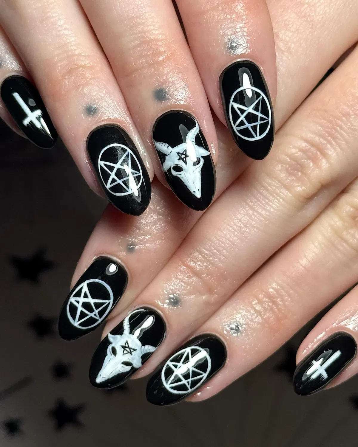 Black nails with white occult-style symbols and skull art