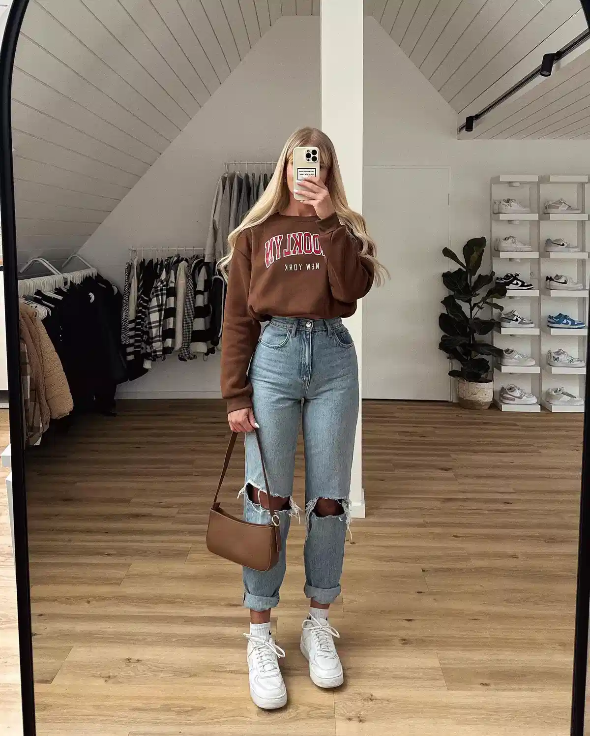 Brown “BROOKLYN” sweatshirt with ripped light-wash jeans