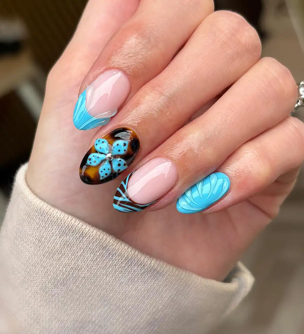 Blue-tipped accents with a brown floral feature nail