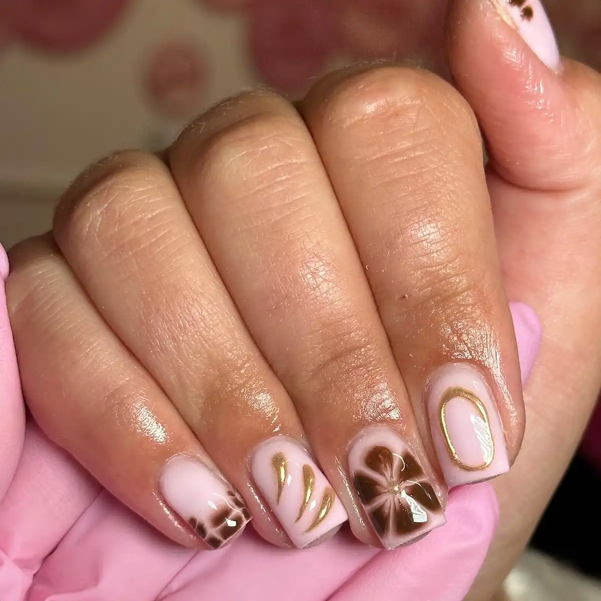 Pale pink base with brown floral art and gold outline details
