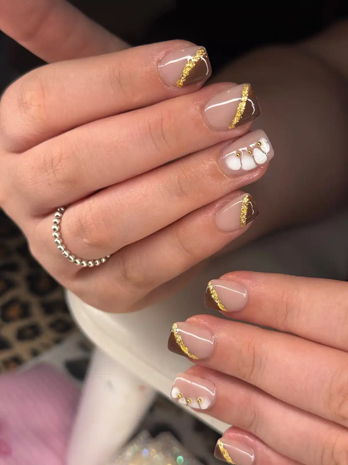 Diagonal brown tips with gold glitter lines and a white 3D accent