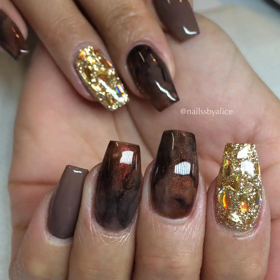 Long square browns with full gold-glitter statement nails