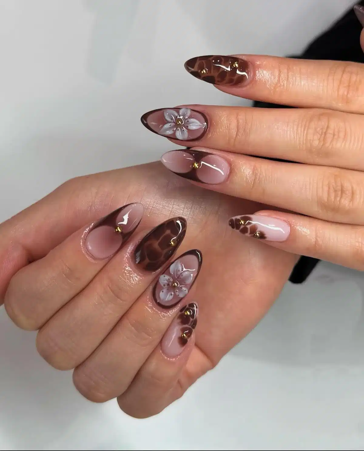 Nude Base with Dark Brown Tips, Floral Accents, and Gold Studs