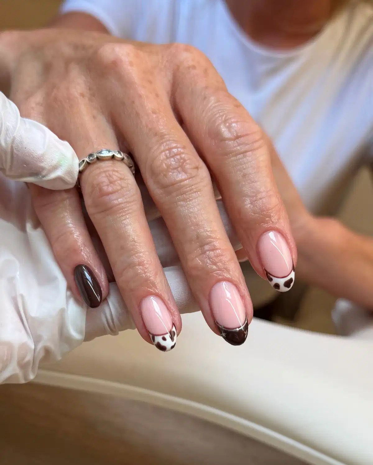 Short brown French tips with spotted accents