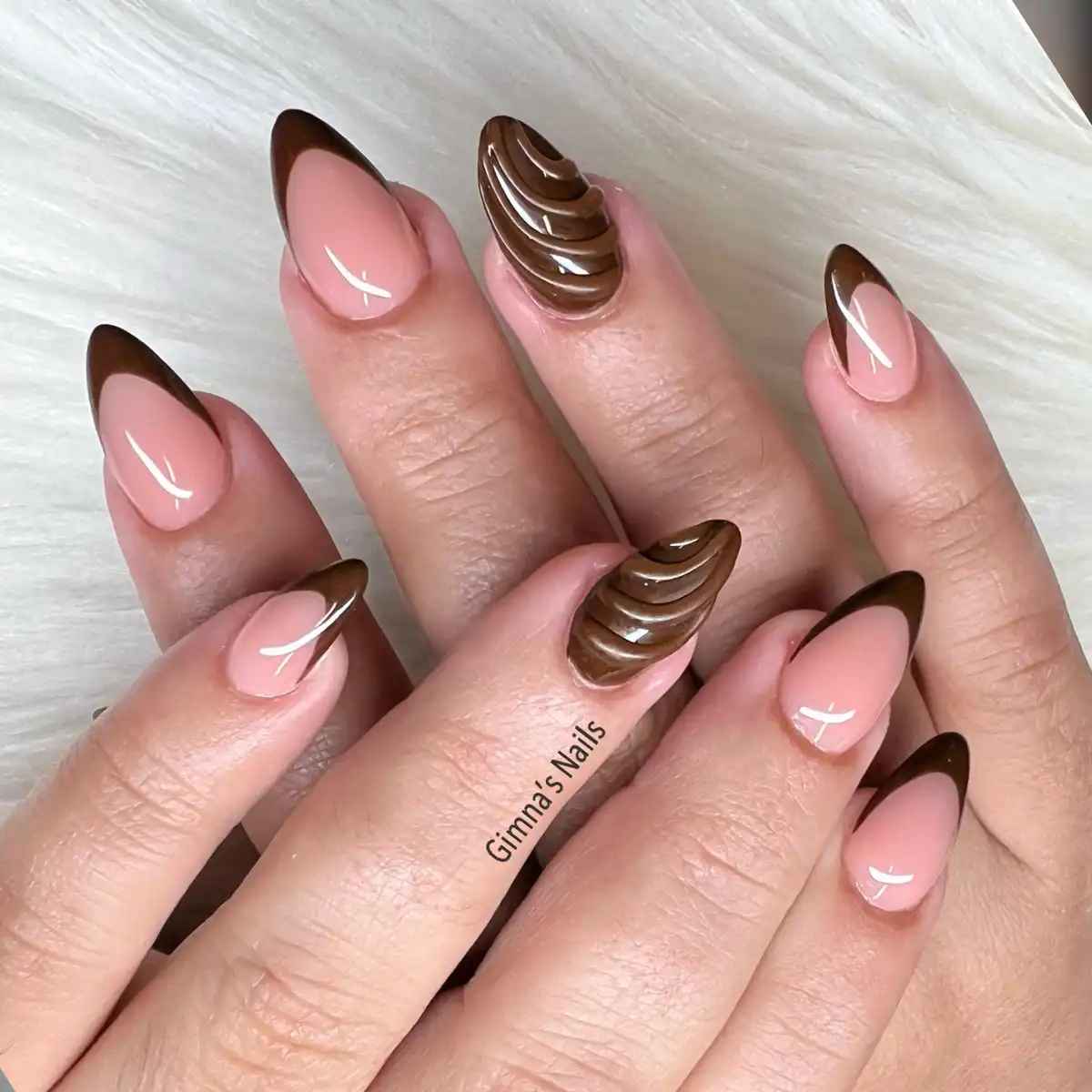 V-shaped brown French tips with raised swirl accents