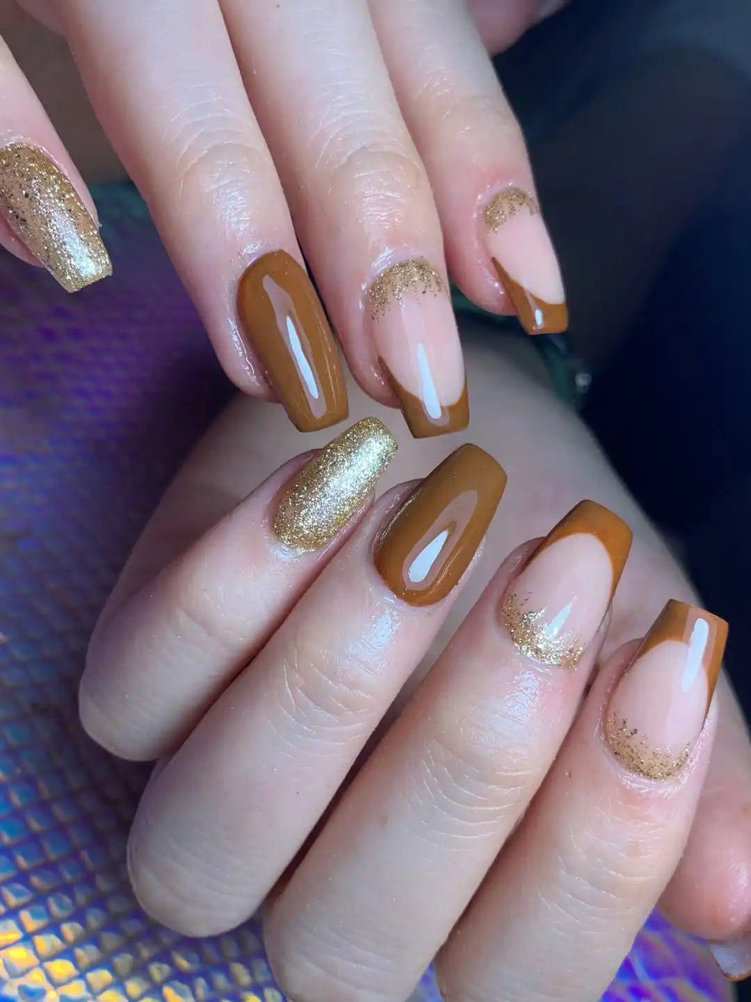 Medium-brown French tips with gold glitter accents