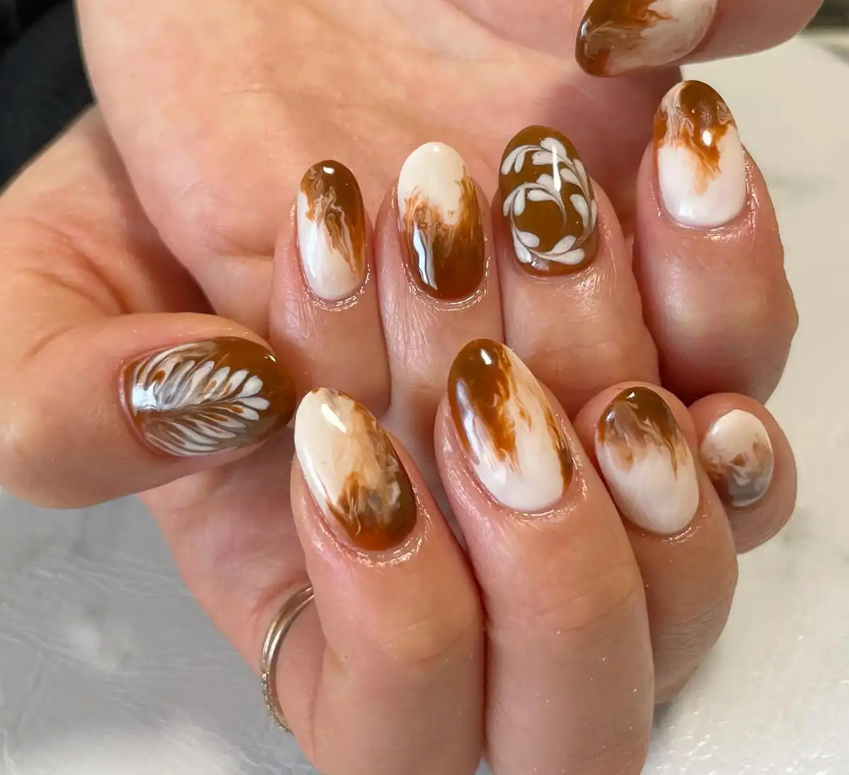 Cream-and-brown brushstroke design with white leaf motifs