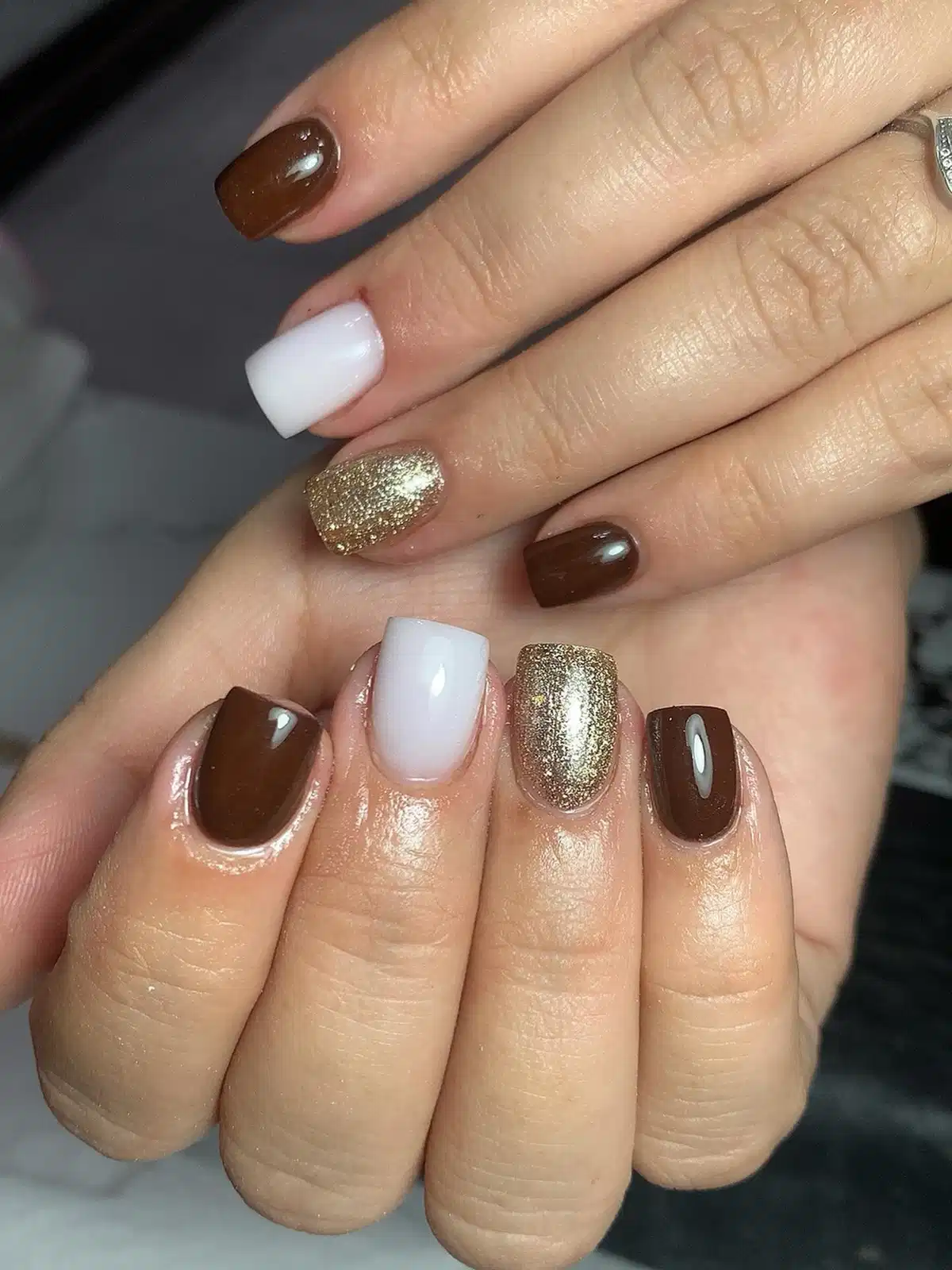 Deep brown and white blocks with gold glitter accent nails