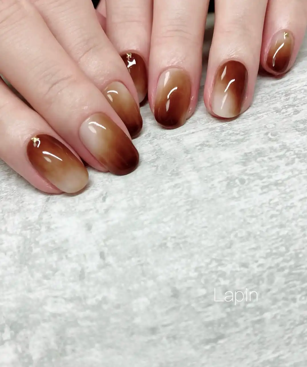 Glossy nude-to-brown gradient with small gold studs