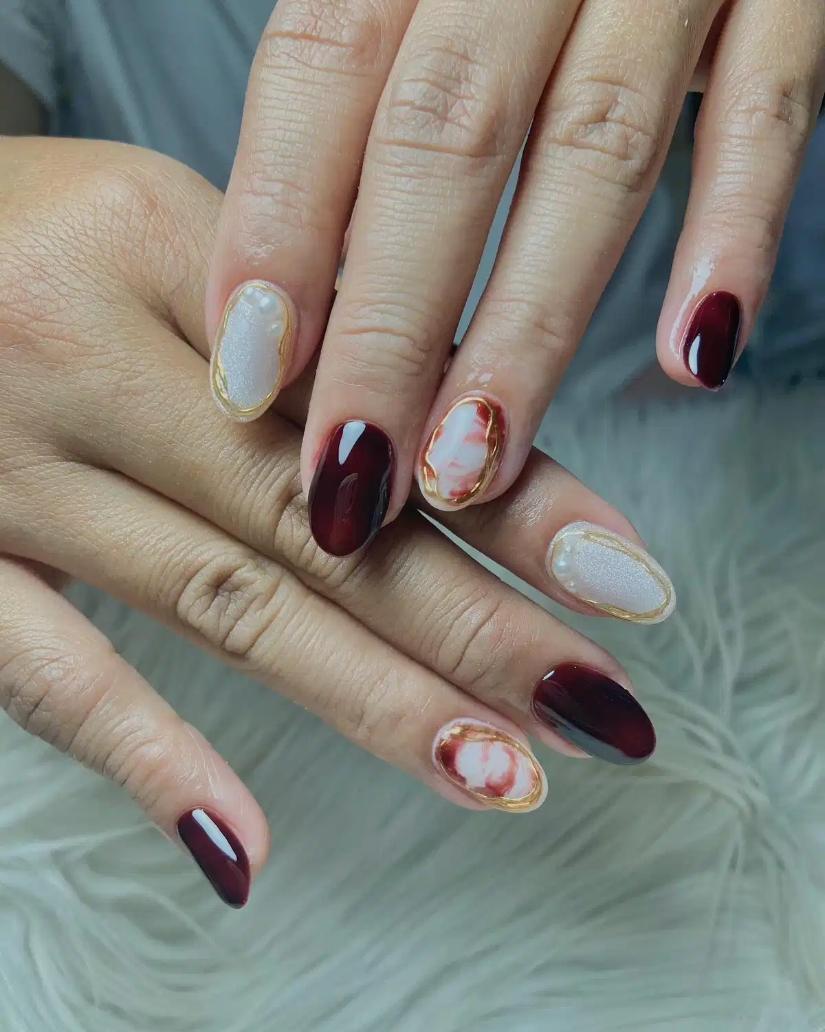 Dark maroon with gold-outlined pearly and marbled accents