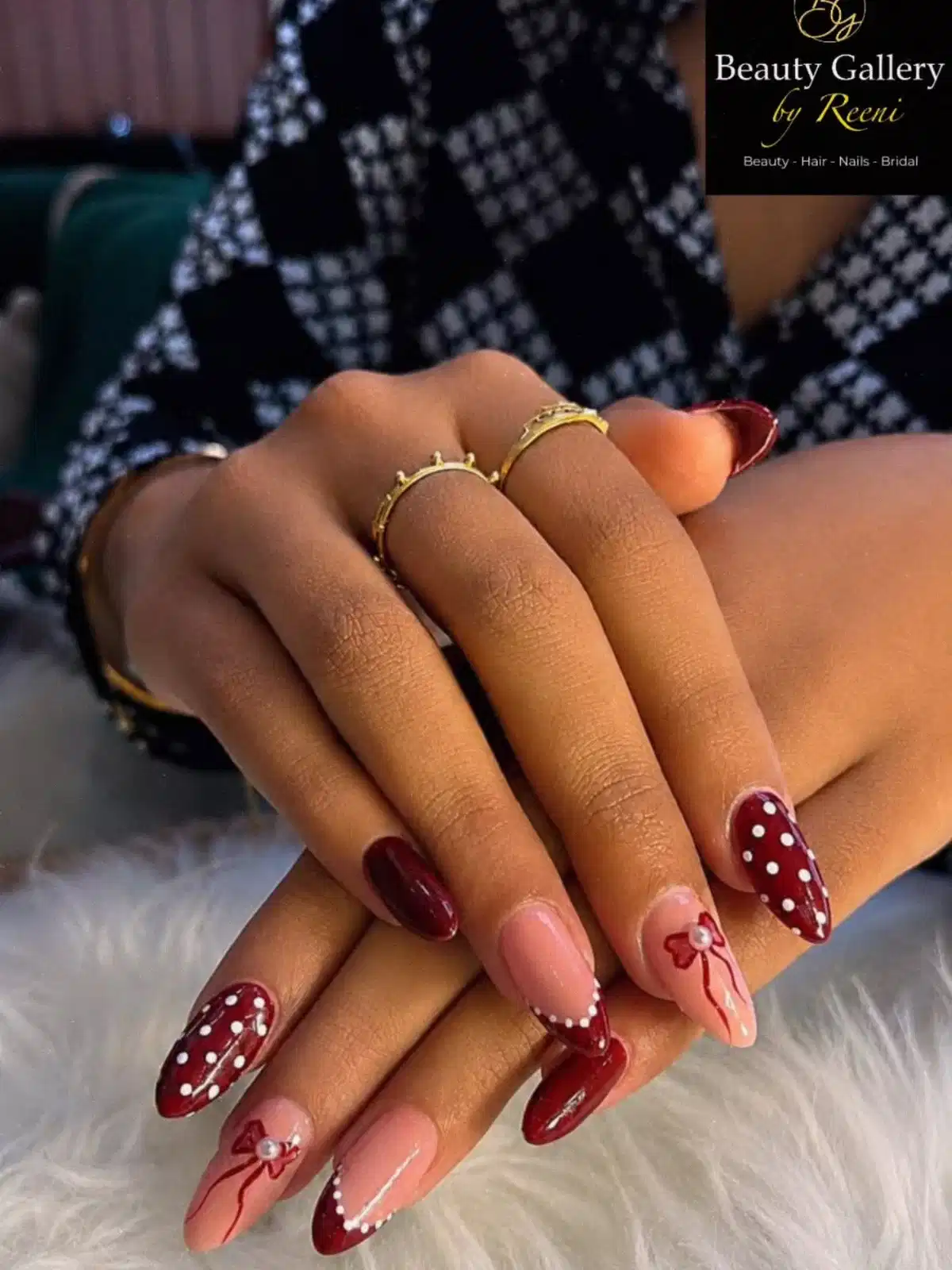 Maroon and nude almond nails with polka dots and bow accent