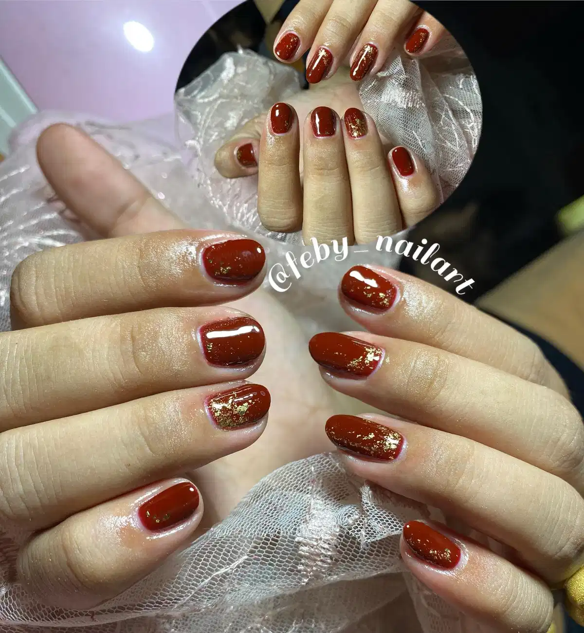 Glossy maroon short nails with gold flake accents