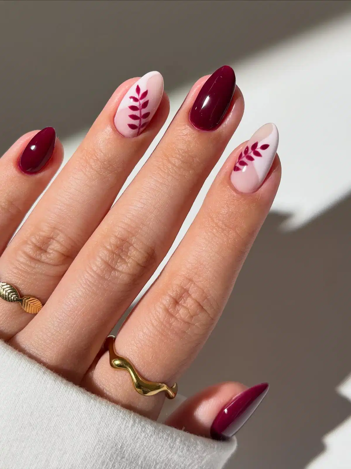 Maroon solids with leaf-branch accent nails
