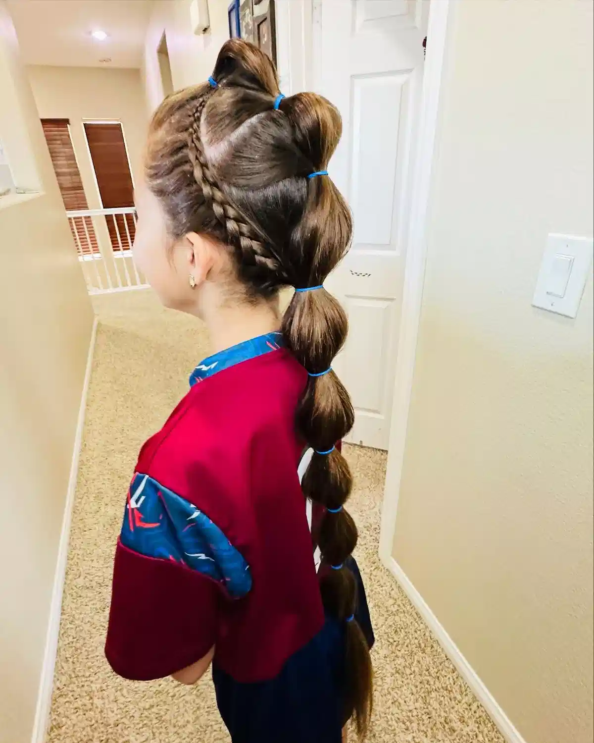 Side braid with blue-tied bubble ponytail