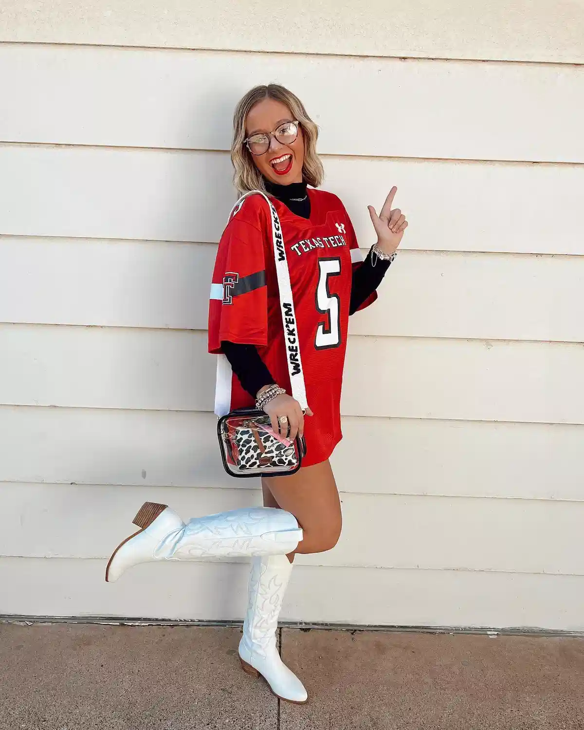 Red “TEXAS TECH” jersey with clear crossbody and white cowboy boots