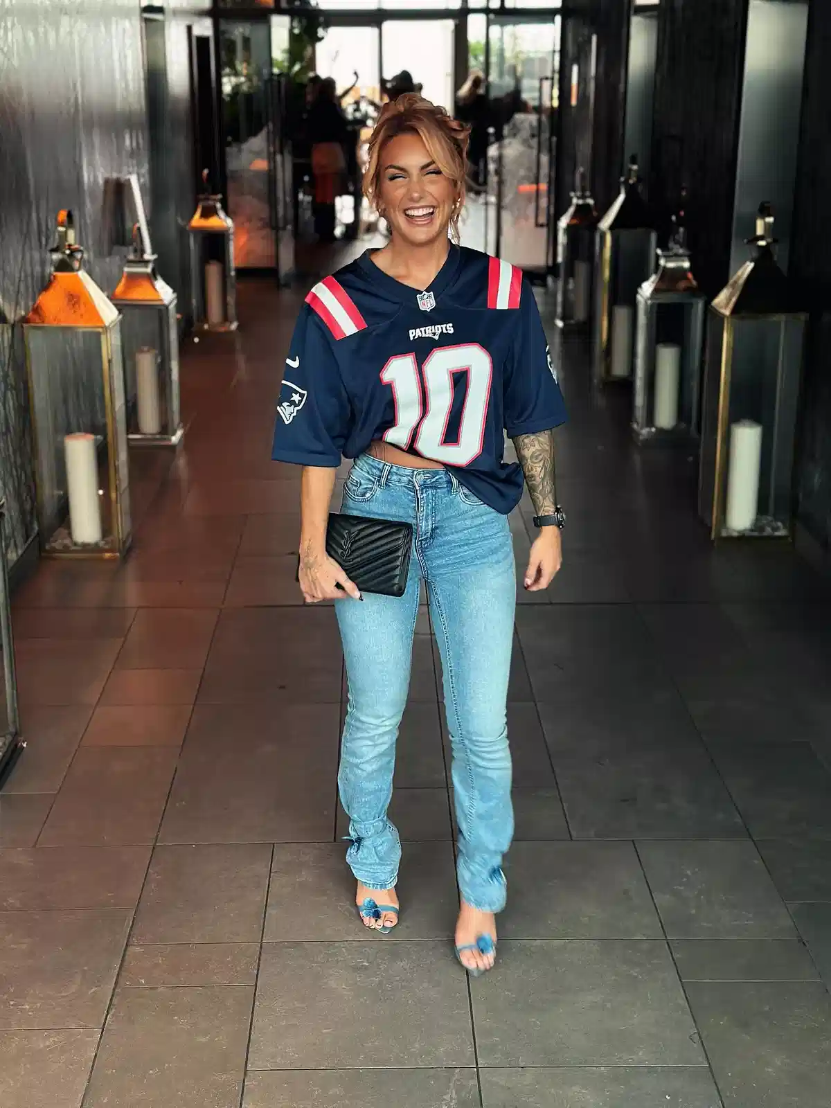Navy “PATRIOTS” number-10 jersey with jeans and blue heels