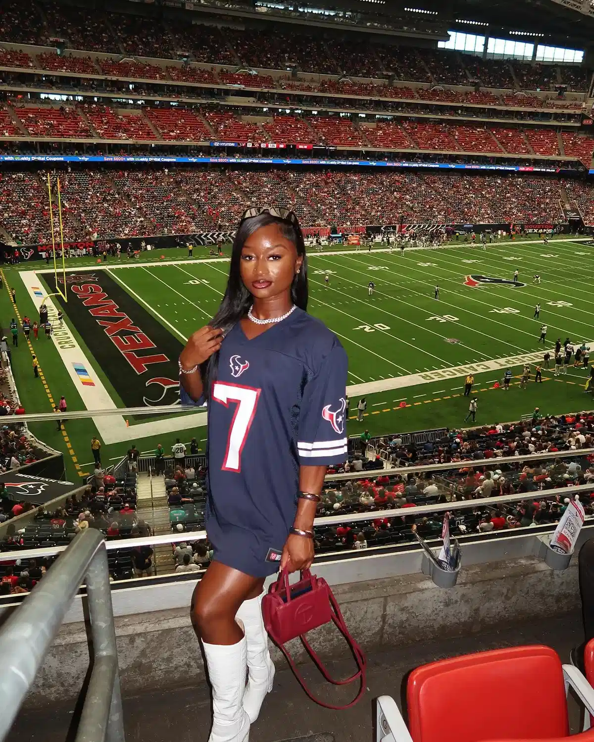 Navy number-7 jersey dress with white boots and red bag