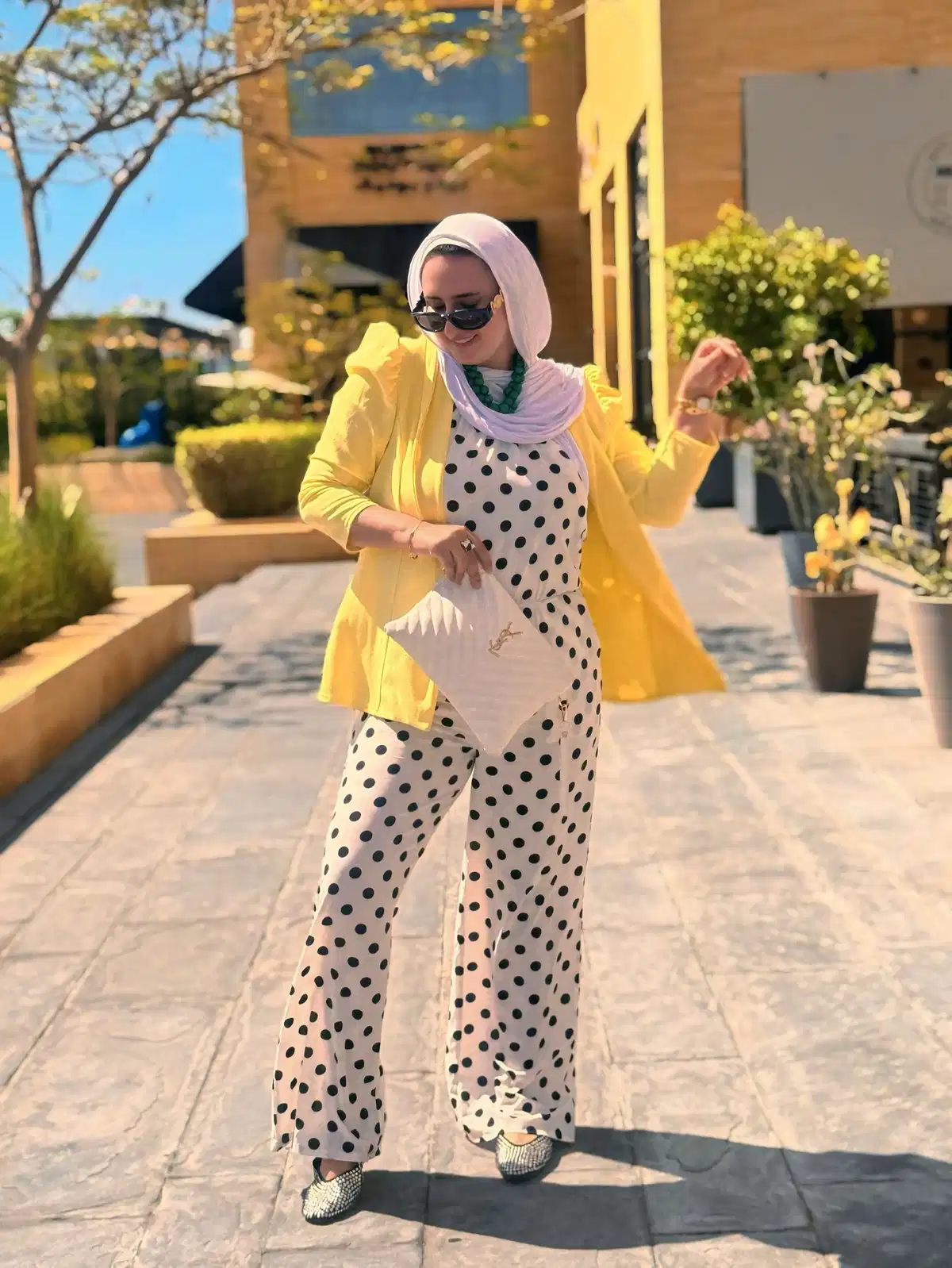 Yellow blazer with polka-dot look and white YSL clutch