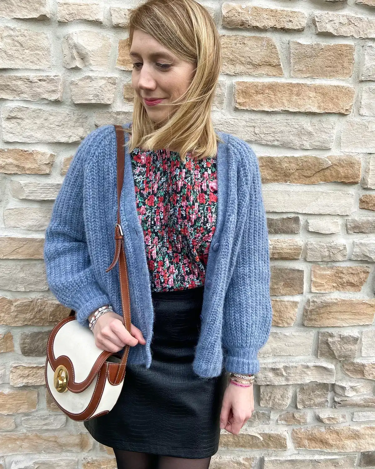 Blue cardigan over floral top with black mini skirt