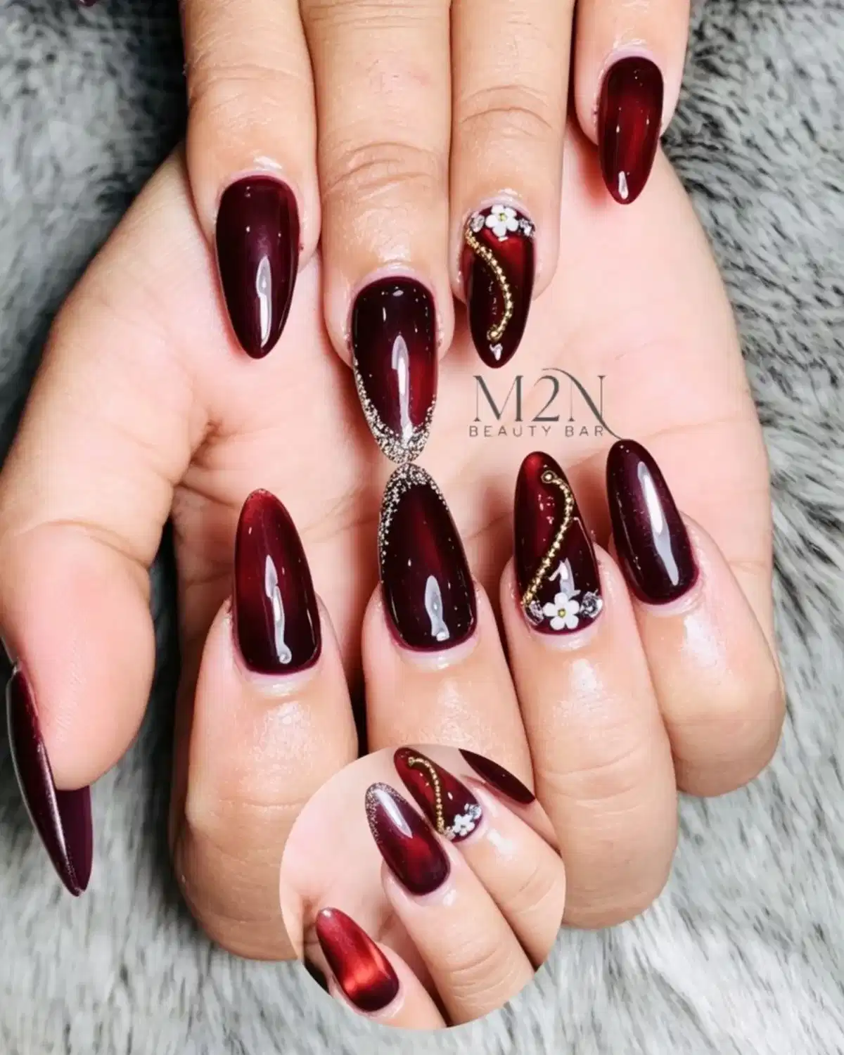 Glossy maroon with gold curves, white flowers, and glitter accent