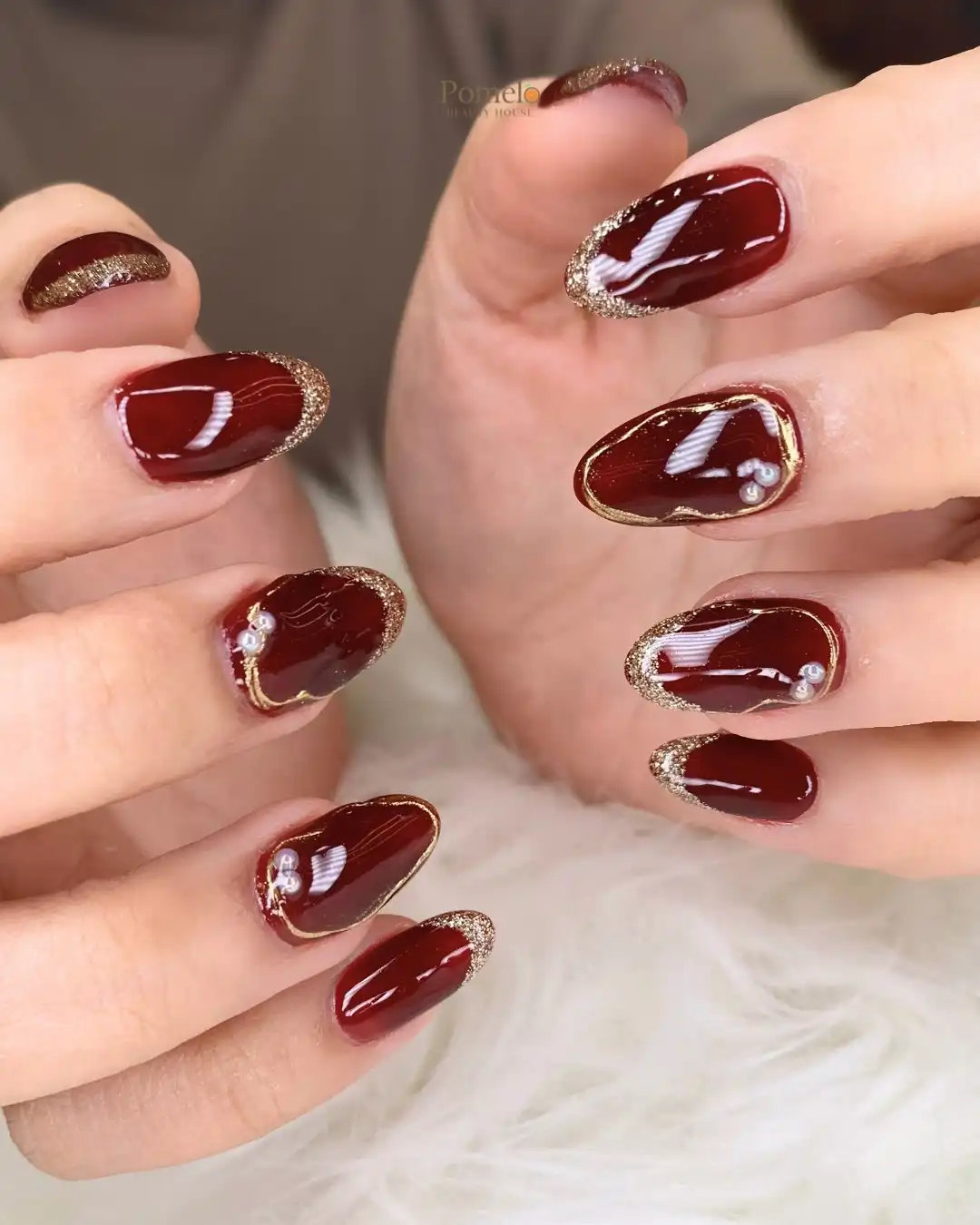 Deep maroon almonds with gold-glitter edging and pearl accents