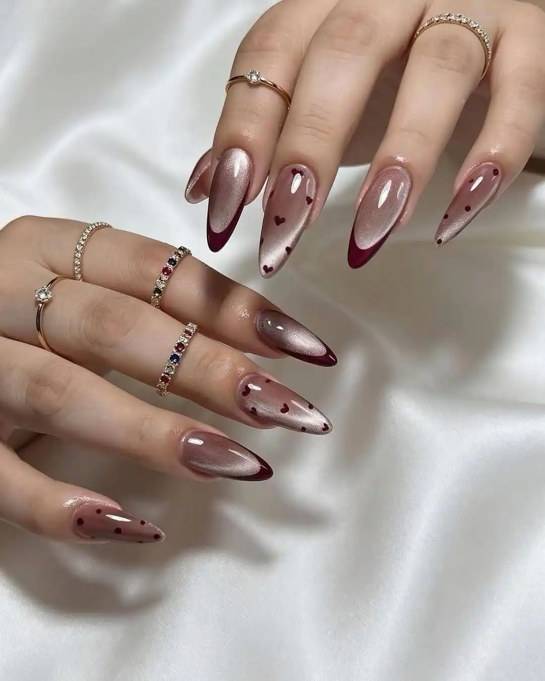 Champagne shimmer base with maroon French tips and tiny hearts
