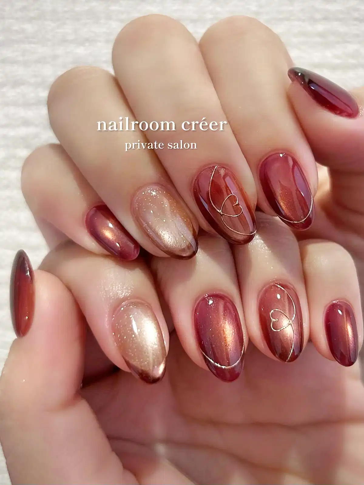 Rose-maroon metallic nails with delicate heart line art