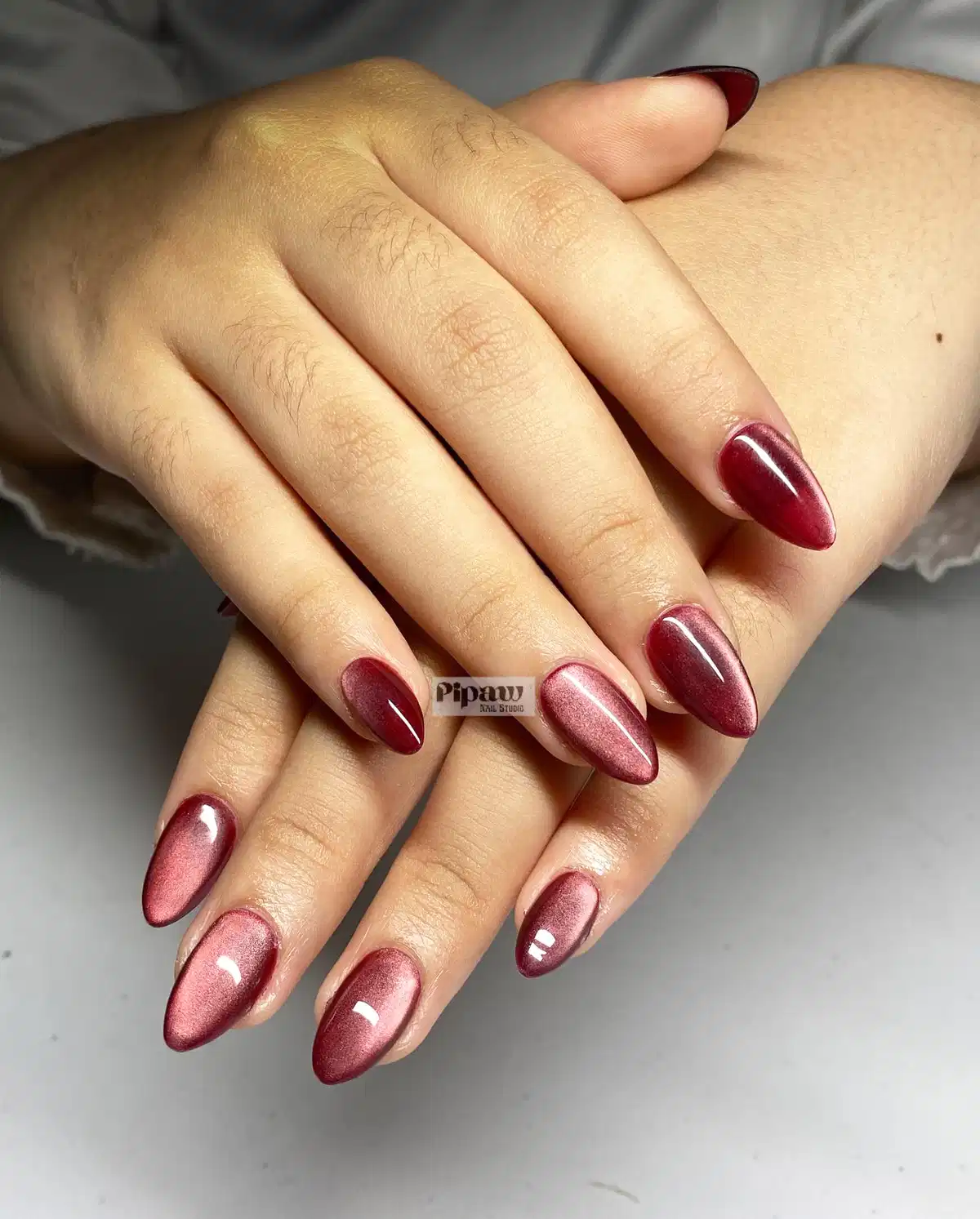 Alternating maroon and rose cat-eye shimmer almonds