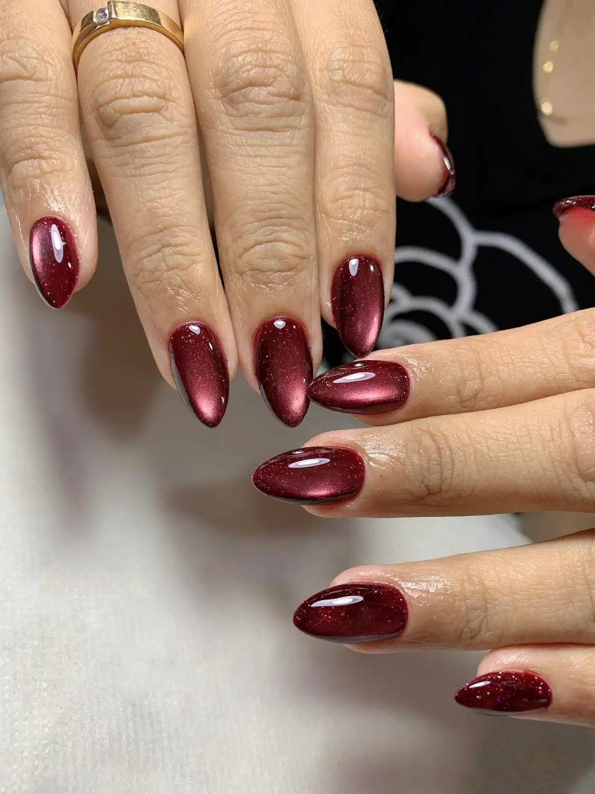 Glossy shimmery maroon almond nails