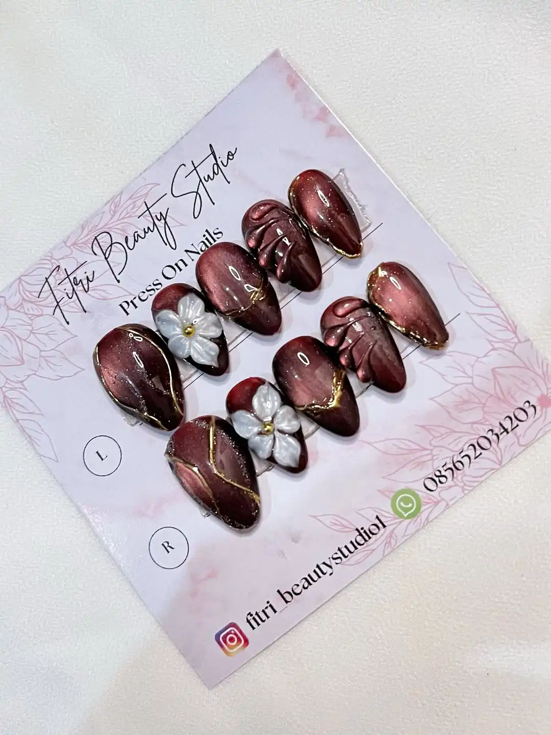 Maroon press-ons with gold edging and raised white flowers