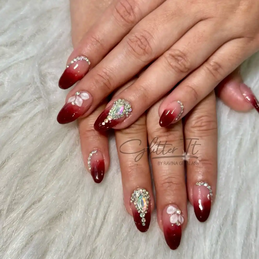 Maroon ombré tips with rhinestones and 3D floral accents