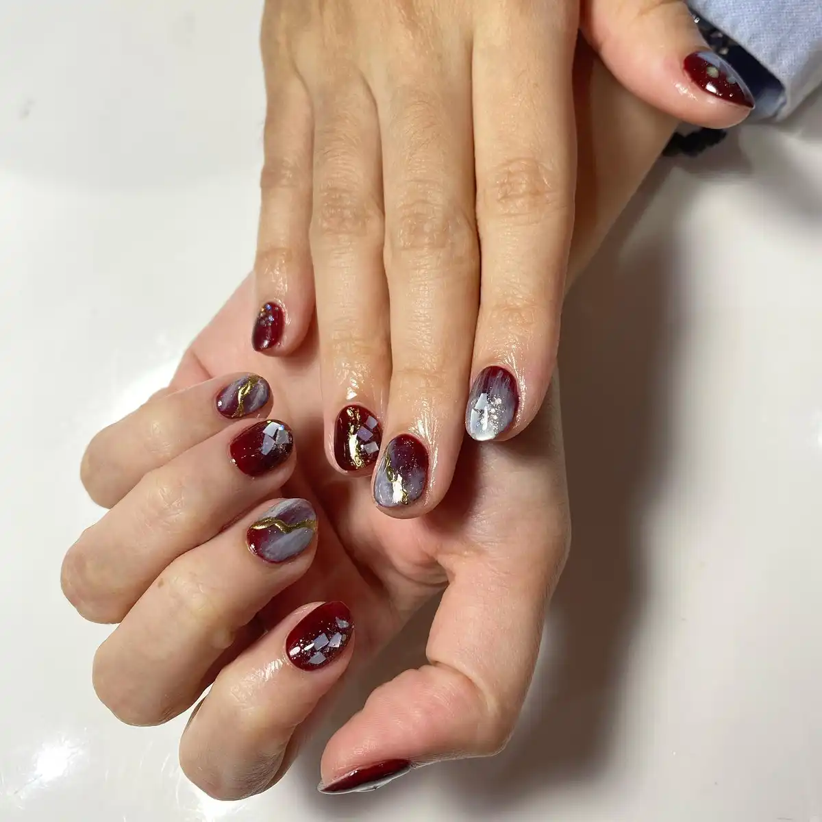 Short maroon-and-gray marble with gold lines and foil fragments